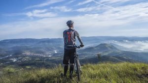 Mountain biker with pack viewing mountains